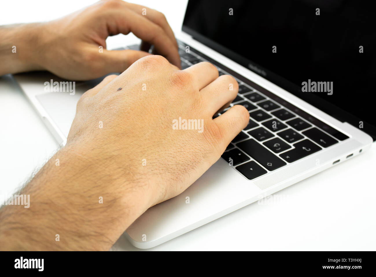Persona di business utilizzando la tastiera di un computer portatile su un tavolo bianco. Persona che lavora in un ufficio. Foto Stock