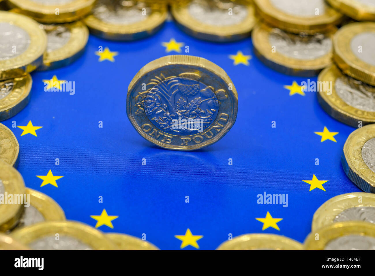 LONDON, Regno Unito - Aprile 2019: Vista ravvicinata della valuta britannica GBP - una sterlina moneta equilibrio sul suo bordo al centro del logo dell'Unione europea. Foto Stock