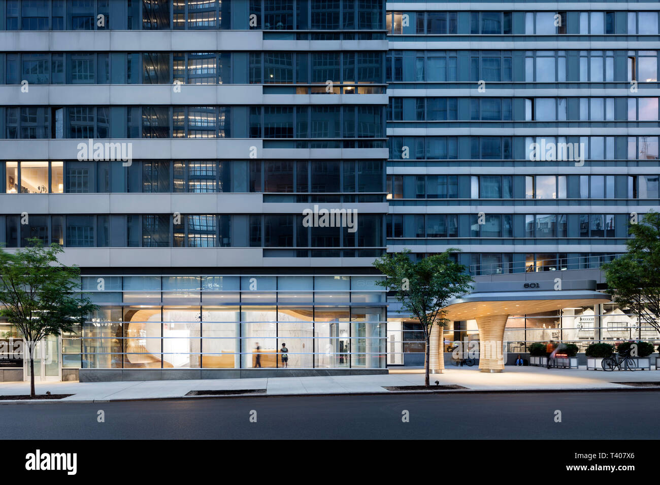 La vista in elevazione della 601 West 57th Street che mostra la lobby illuminata al crepuscolo. Helena 57 West, New York, Stati Uniti. Architetto: Studio V Architettura Foto Stock