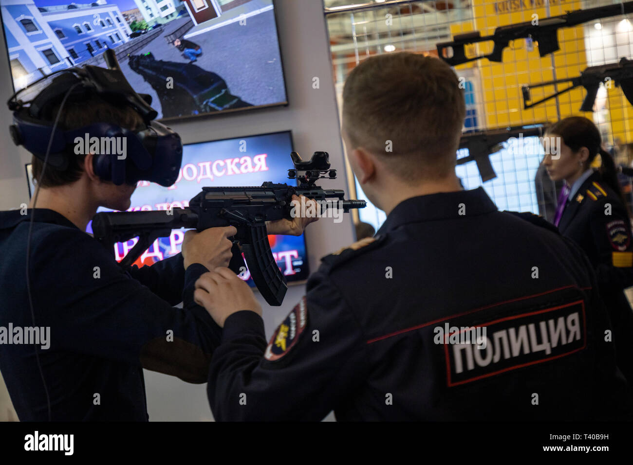 Un funzionario di polizia aiuta il visitatore sulla realtà virtuale simulatore per le forze di polizia delle forze speciali presso lo stand del Nizhny Novgorod Accademia di polizia Foto Stock