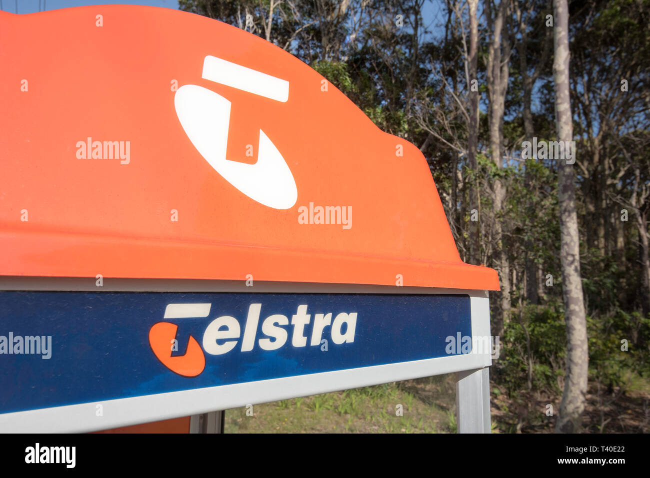 Il caratteristico colore arancione in alto di un tradizionale pubblico Telstra Phone Booth su un sentiero in un villaggio rurale ormai quasi ridondante dovuta a telefoni cellulari Foto Stock