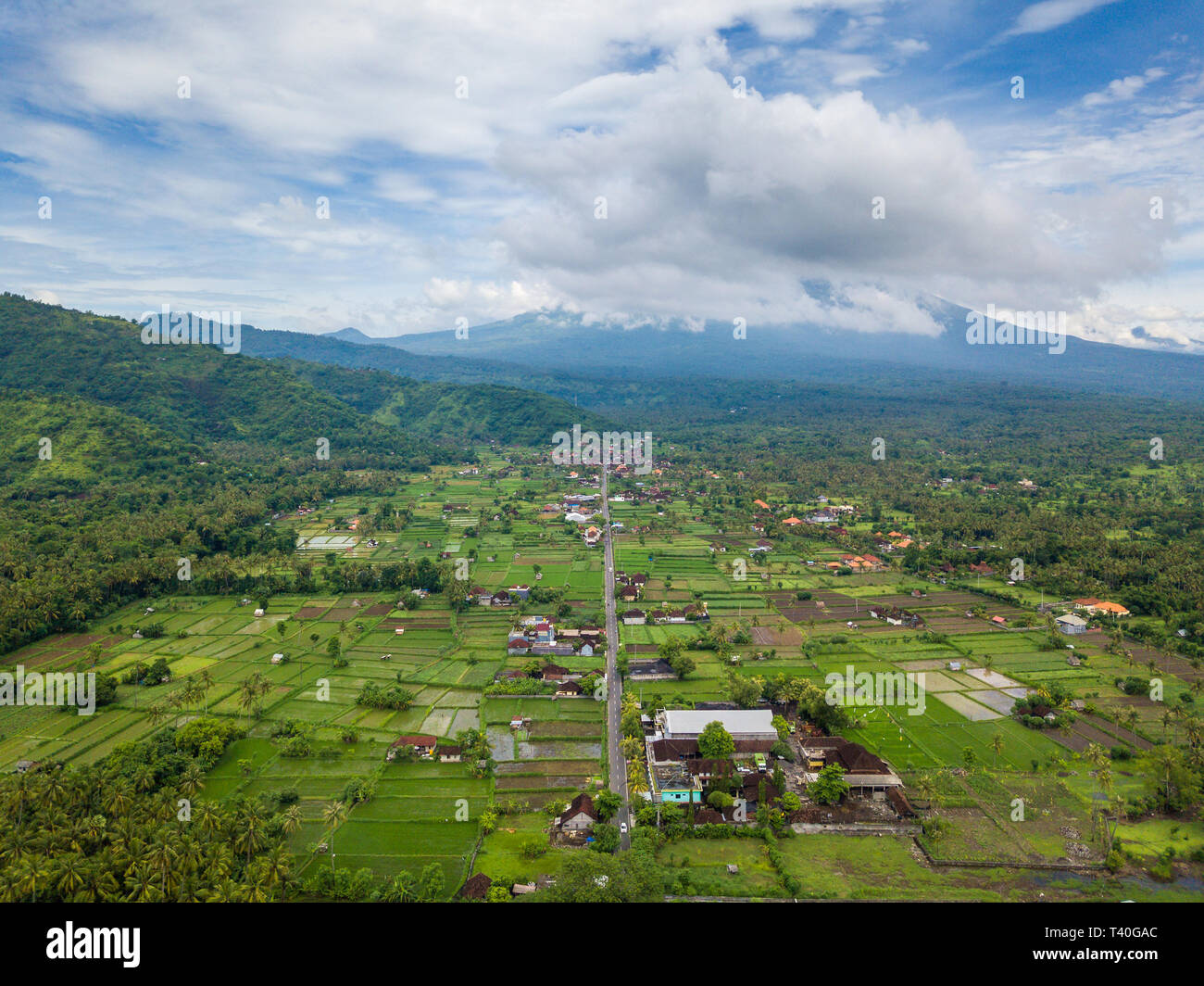 Vista aerea di Amed in Bali, Indonesia. Gunung Agung vulcano sullo sfondo, parzialmente coperto dalle nuvole. Foto Stock