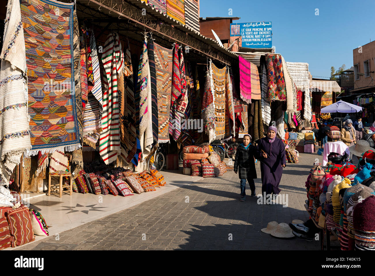 Donna e bambino a camminare intorno all'aria aperta souk di Marrakech, Marocco Foto Stock