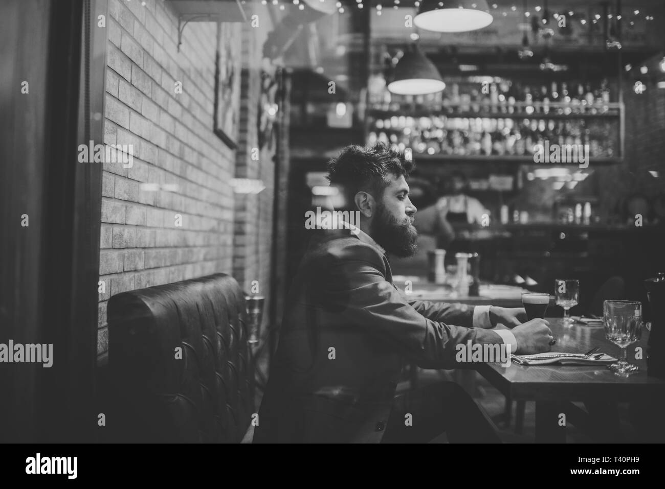 Uomo Barbuto resto nel ristorante con bicchiere da birra. grave bar cliente sedersi a bere caffè ale. Data riunione del hipster in attesa nel pub. Tempo di birra Foto Stock