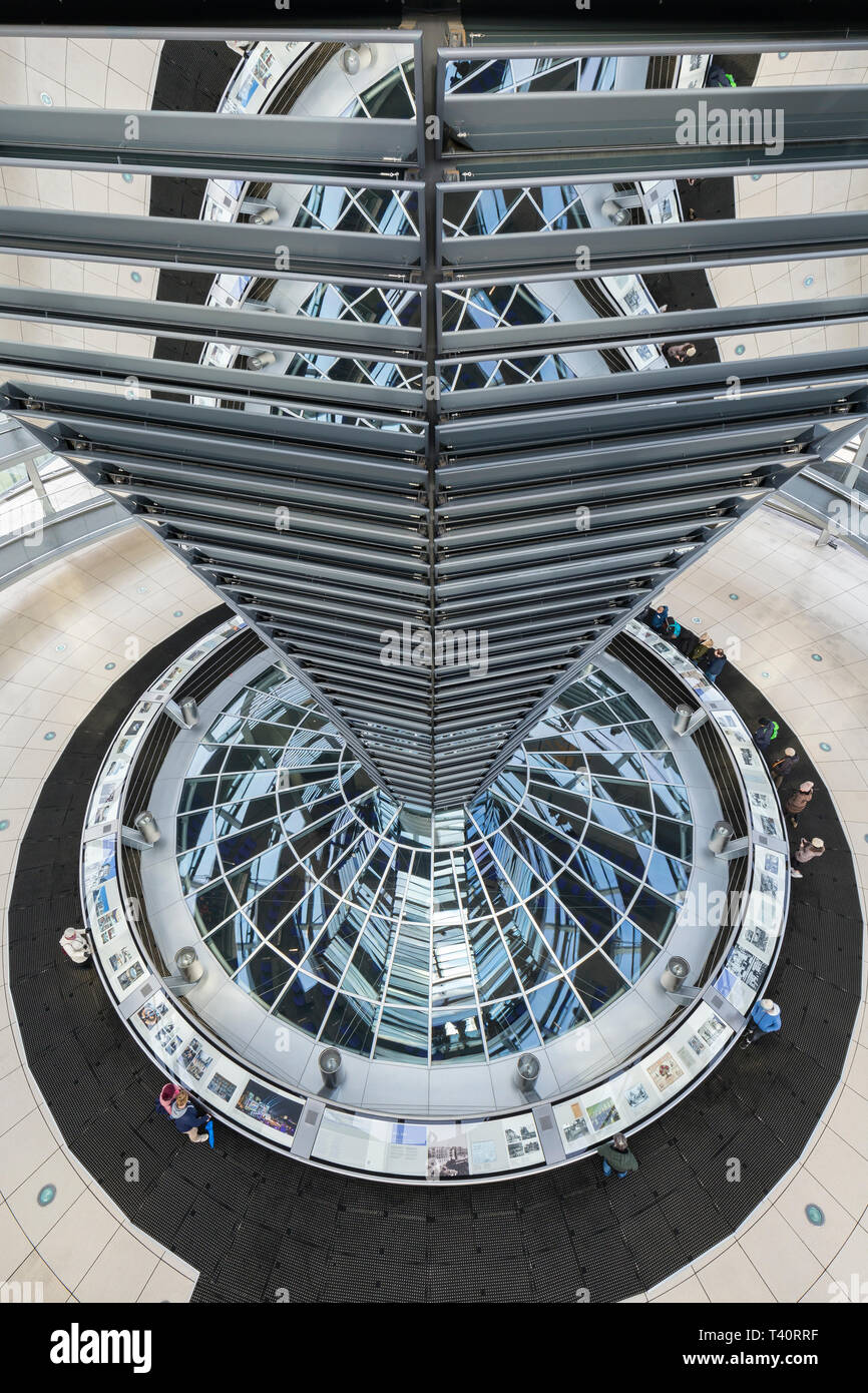 Ad alto angolo di visione del mirroring e del cono interno della futuristica cupola di vetro sulla parte superiore del Reichstag (parlamento tedesco) edificio di Berlino, Germania. Foto Stock