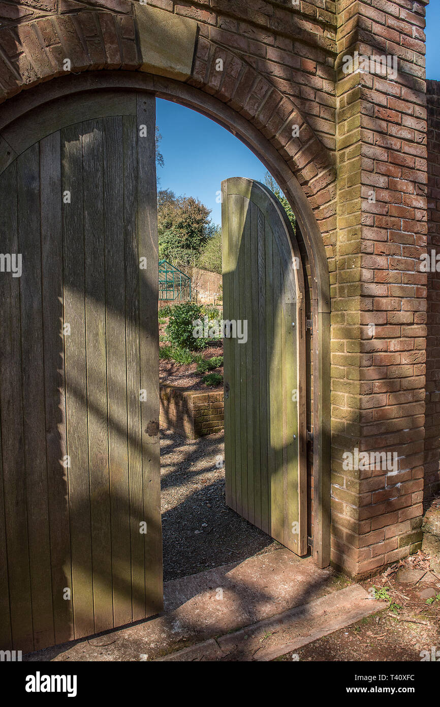 Porta segreta in walled garden Foto Stock