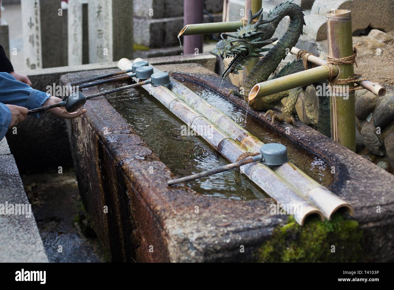 In prossimità di una persona lavare le mani in acqua significava per la purificazione, a Nara, Giappone. Foto Stock