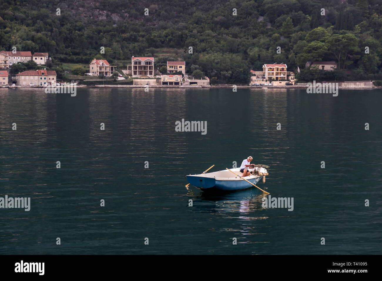 Baia di Kotor, Montenegro, 19 Settembre 2018: pescatore in una barca impostazione trappole di pesce Foto Stock