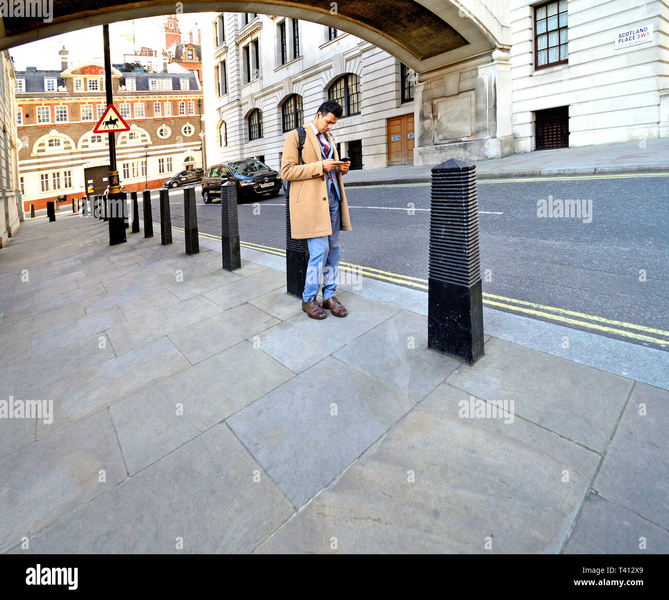 Londra, Inghilterra, Regno Unito. L'uomo sul suo telefono cellulare in Scozia Place, Westminster Foto Stock