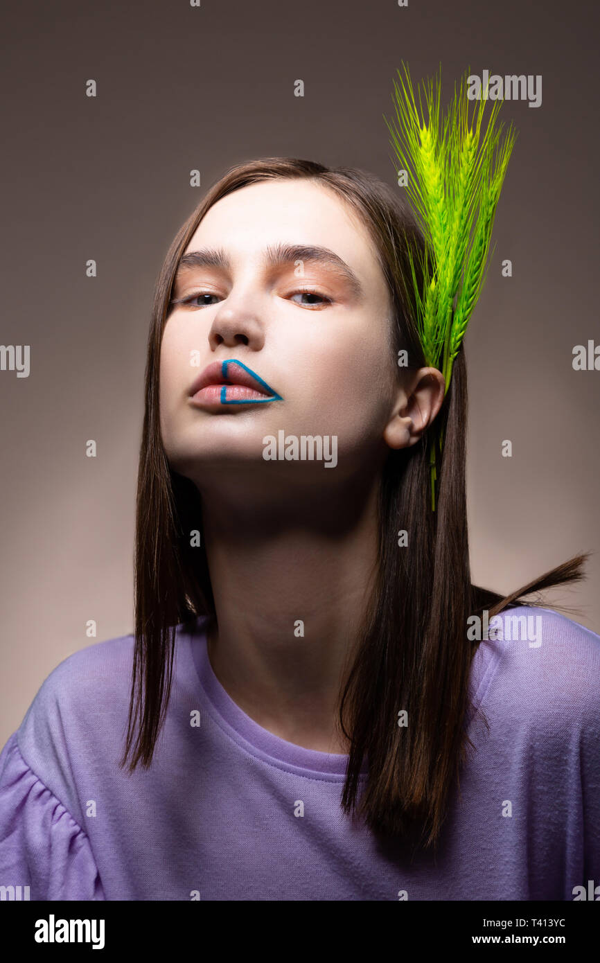 Modello con capelli scuri aventi spikelet verde nei suoi capelli Foto Stock