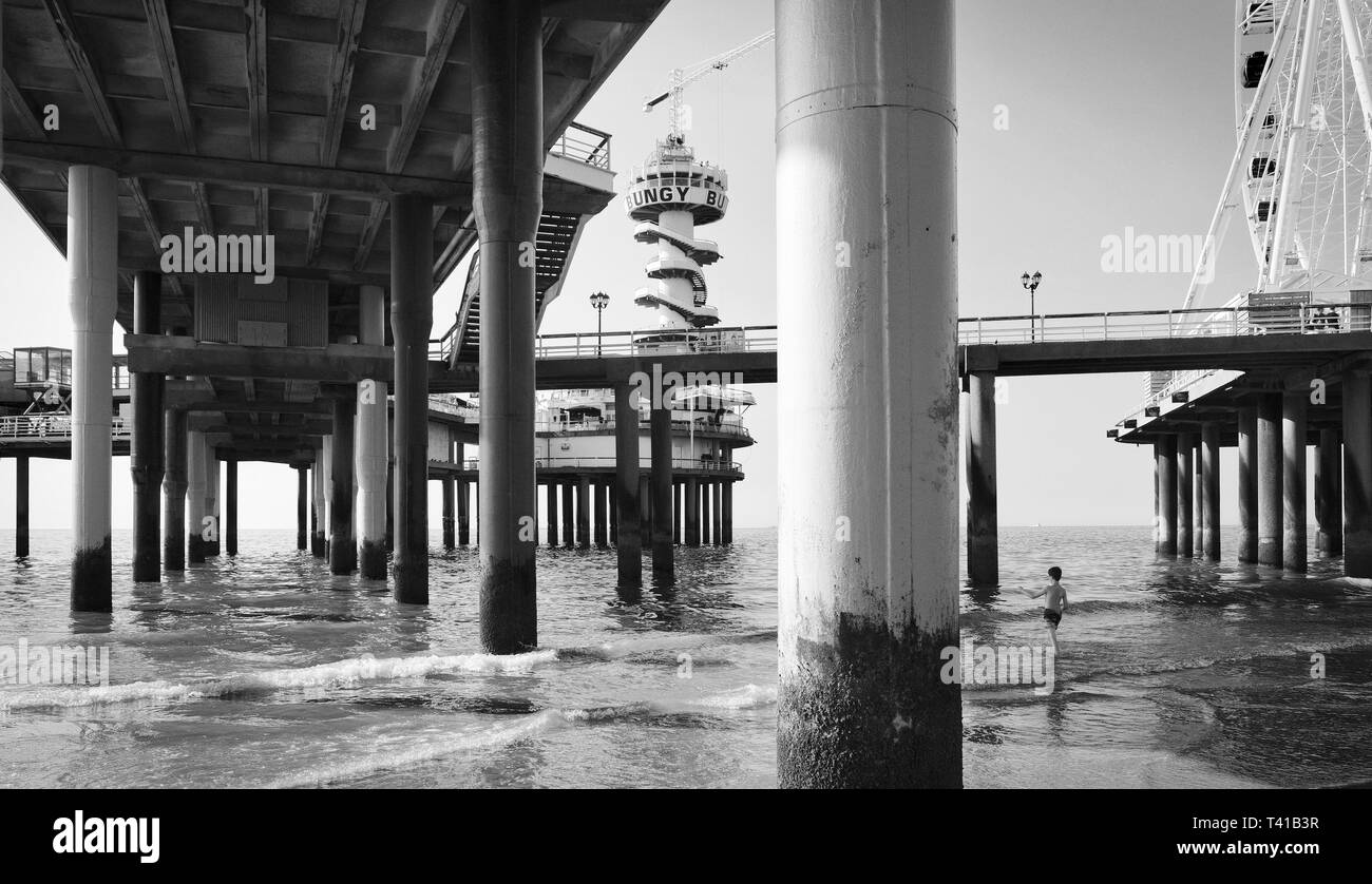 Basso angolo di visione su pali di un molo in mare in estate a Scheveningen, Paesi Bassi Foto Stock
