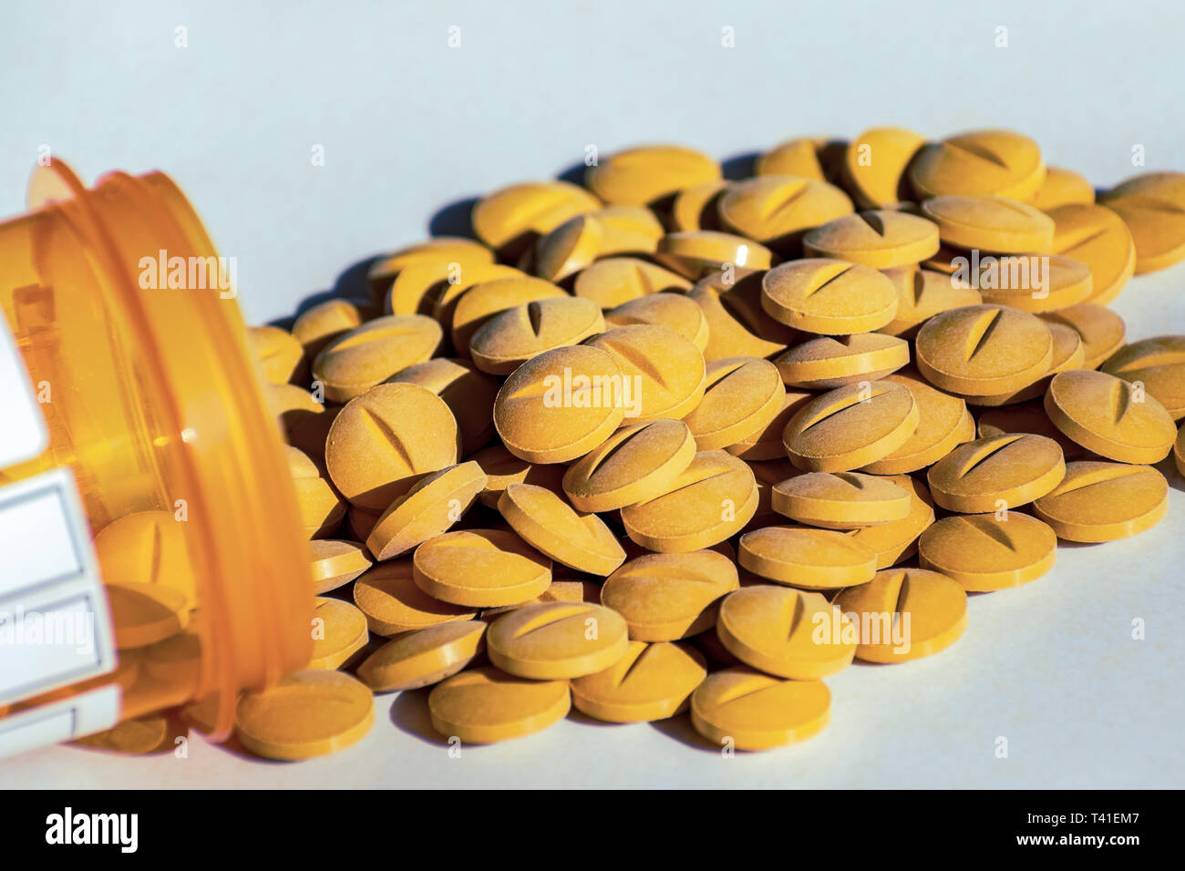 Giallo pillole di prescrizione versato su una tabella. Concetto di dipendenza da oppiacei e settore sanitario Foto Stock