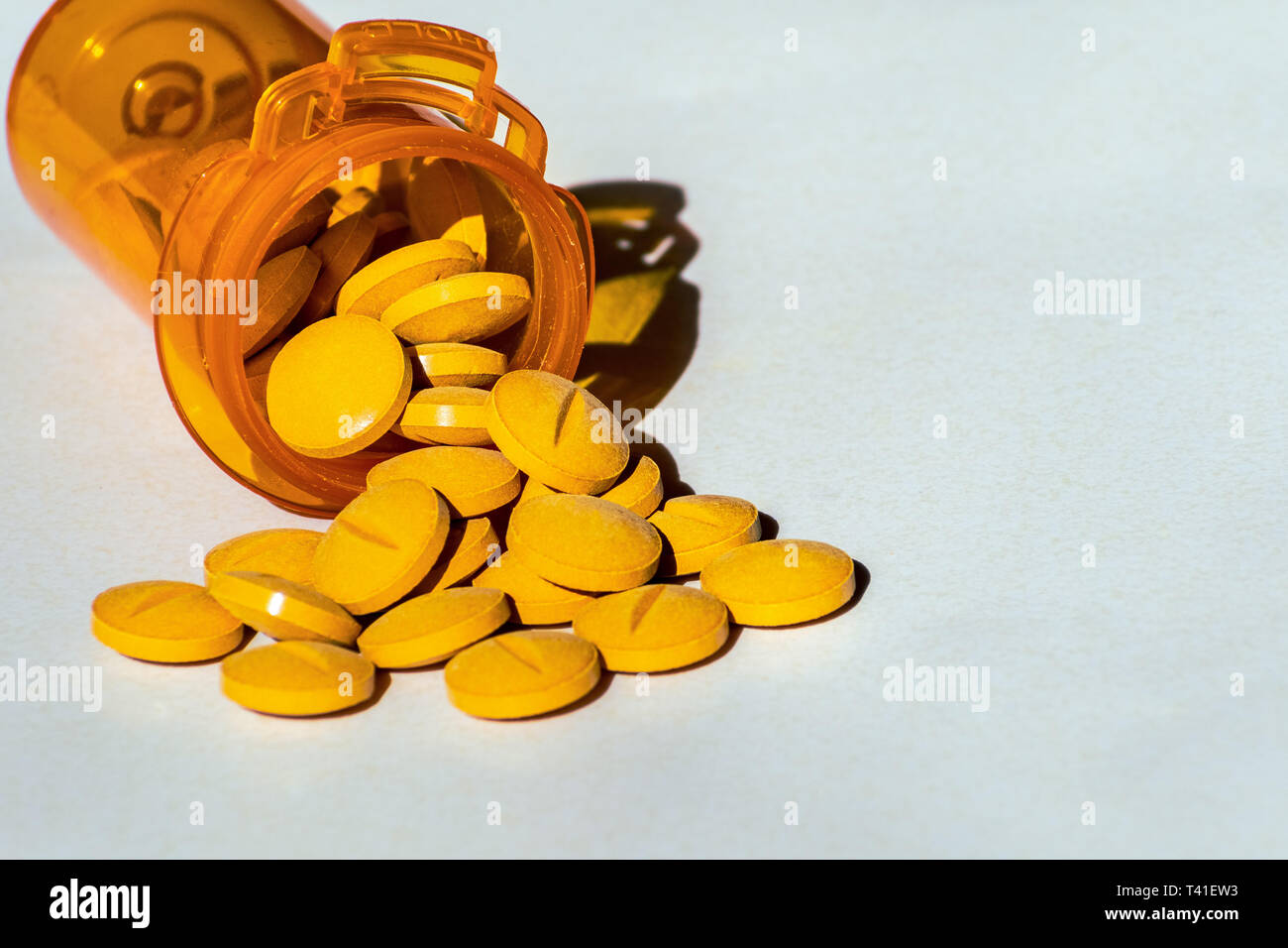 Giallo pillole di prescrizione versato su una tabella. Concetto di dipendenza da oppiacei e settore sanitario Foto Stock