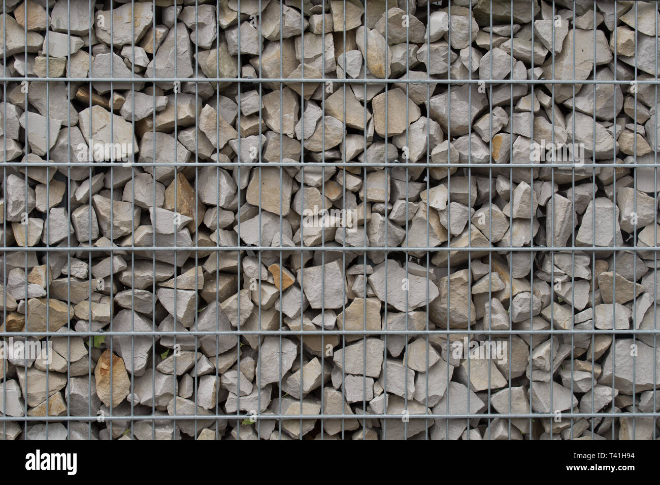 Recinzione di protezione o muro fatto di gabions con pietre grigie Foto Stock