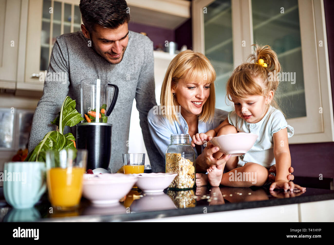 Famiglia con cute girl avente la colazione nella cucina Foto Stock