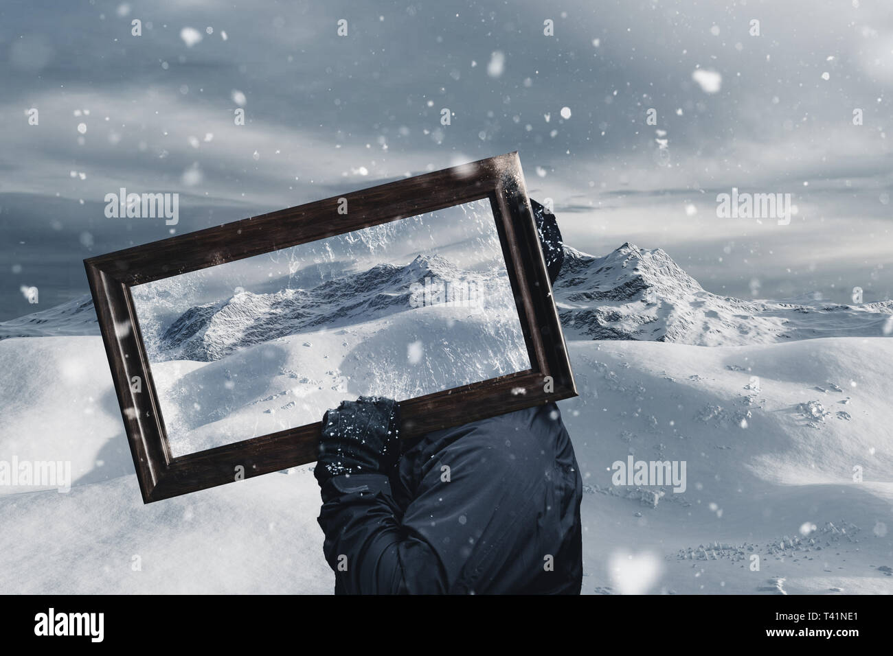 Escursionista tenendo il telaio dello specchietto di fronte coperta di neve la gamma della montagna Foto Stock
