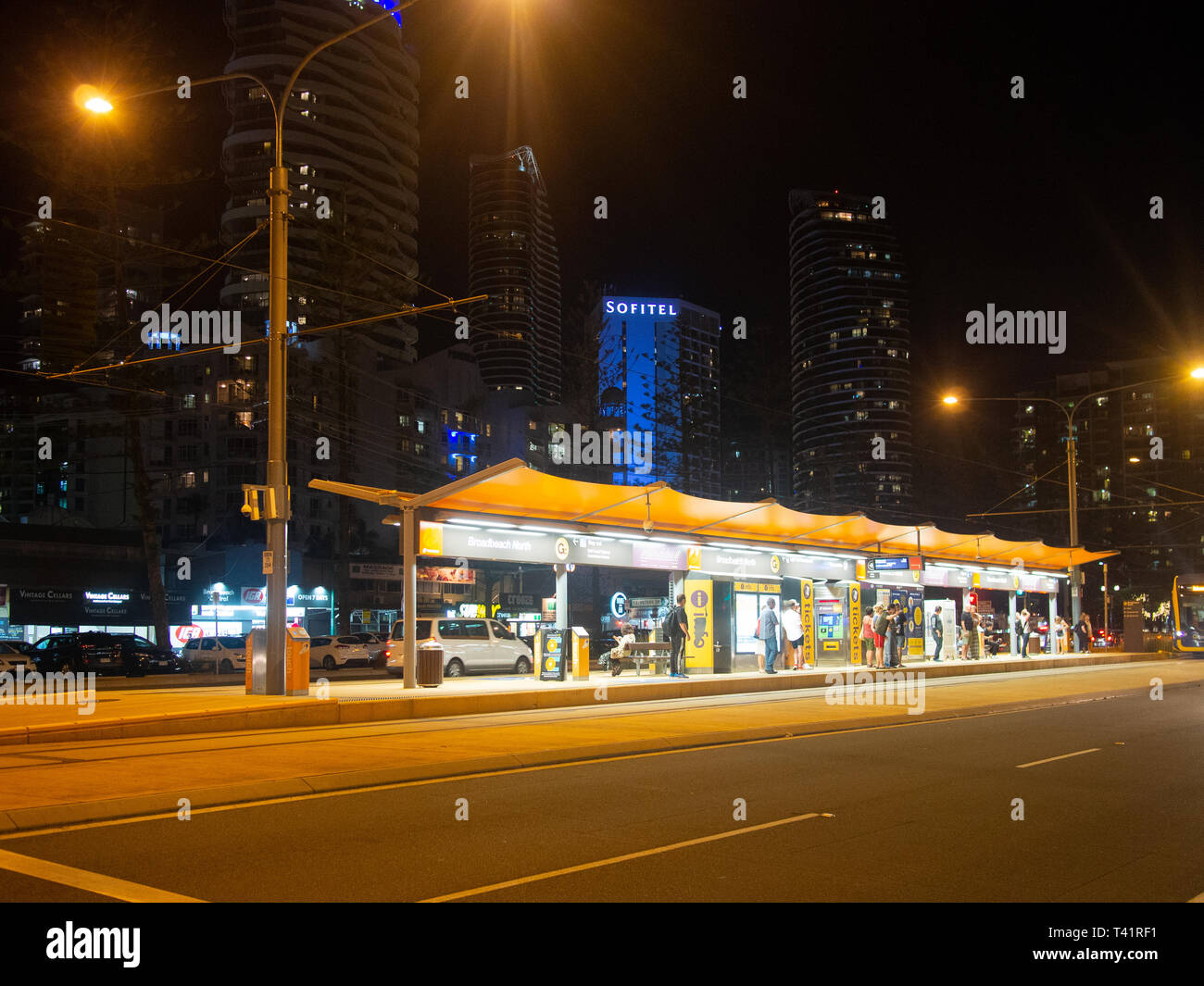 Persone in attesa a un Light Rail Station in Broadbeach di notte Foto Stock