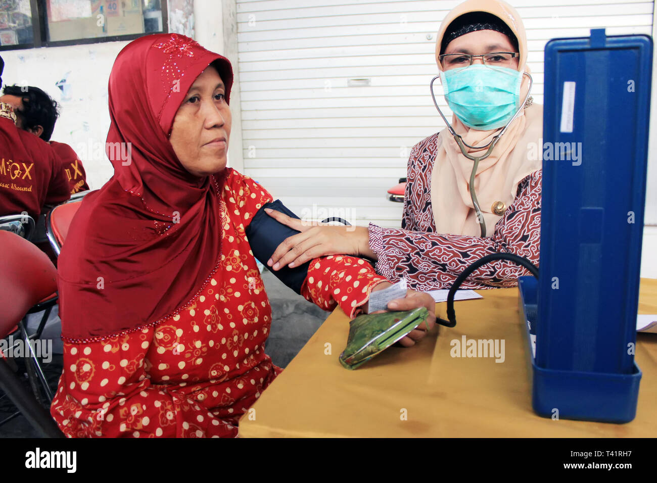 Surabaya indonesia, 24 maggio 2012. Un lavoratore di salute sta controllando la pressione sanguigna di un paziente Foto Stock