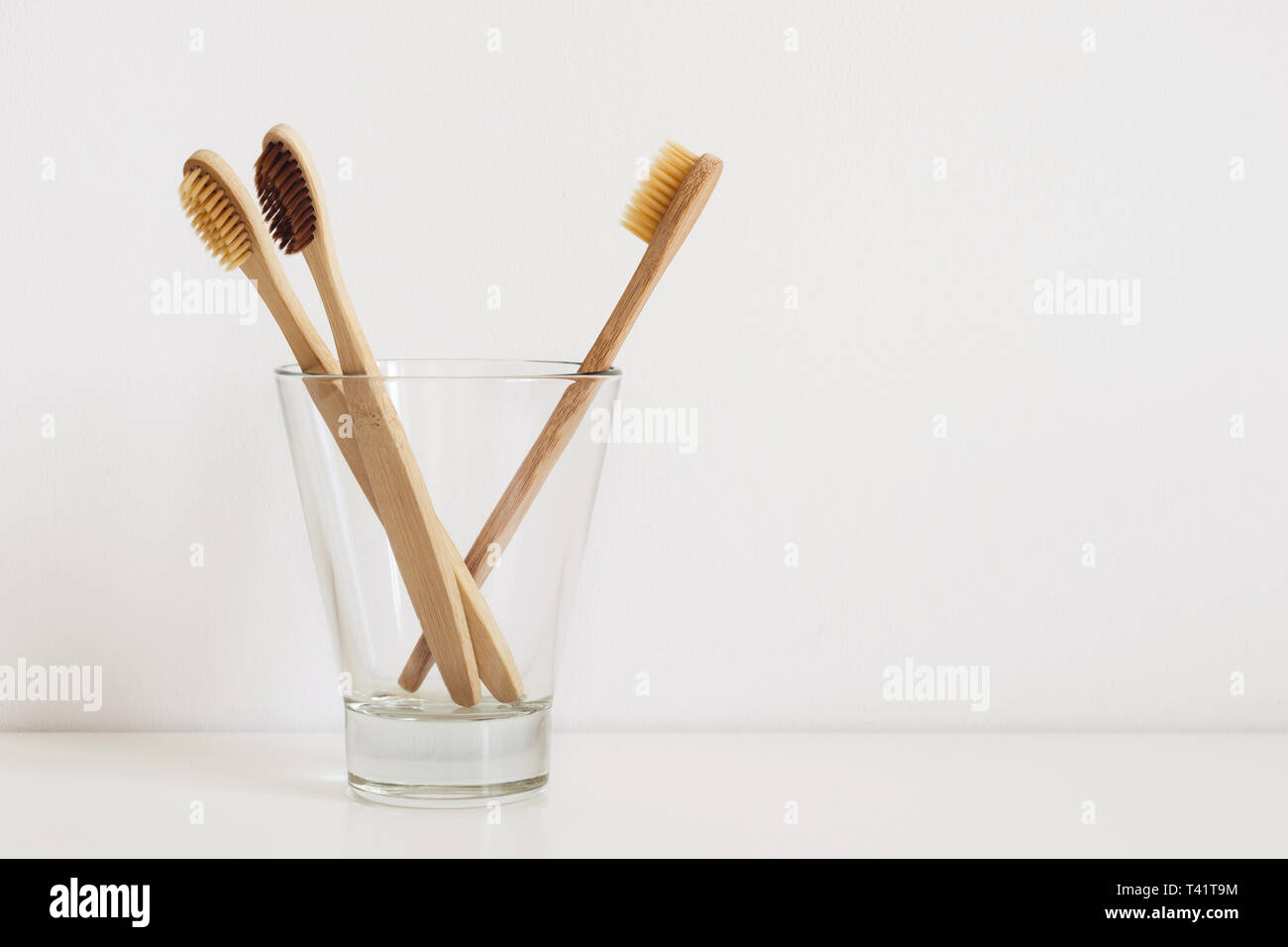 Set di spazzolini da denti naturali in vetro sulla tavola in bagno. Foto Stock