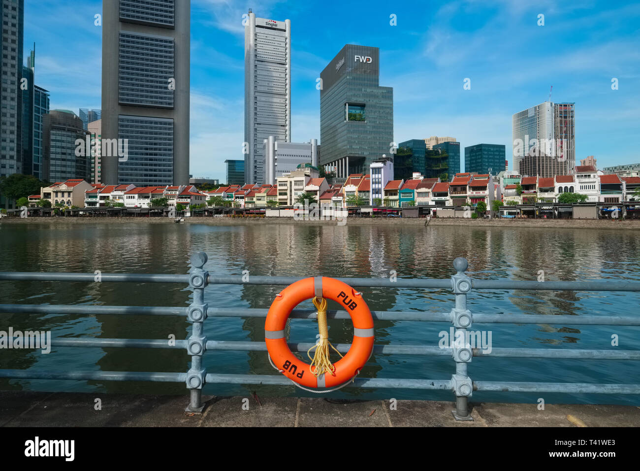 Una benedizione attaccato mediante i servizi di pubblica utilità scheda (pub) alla ringhiera lungo il Fiume Singapore e Boat Quay, Singapore; b/g: il quartiere finanziario Foto Stock