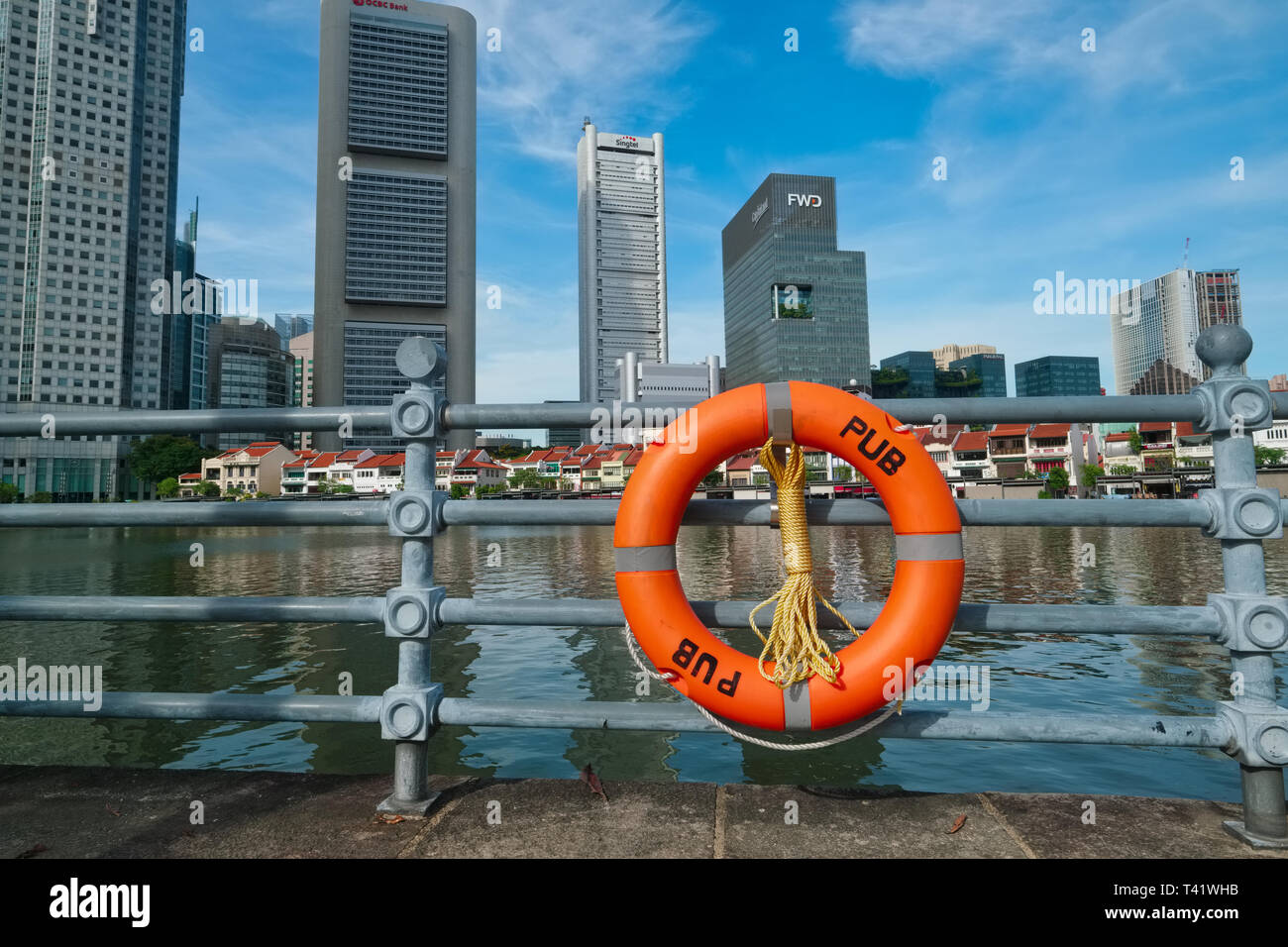 Una benedizione attaccato mediante i servizi di pubblica utilità scheda (pub) alla ringhiera lungo il Fiume Singapore e Boat Quay, Singapore; b/g: il quartiere finanziario Foto Stock