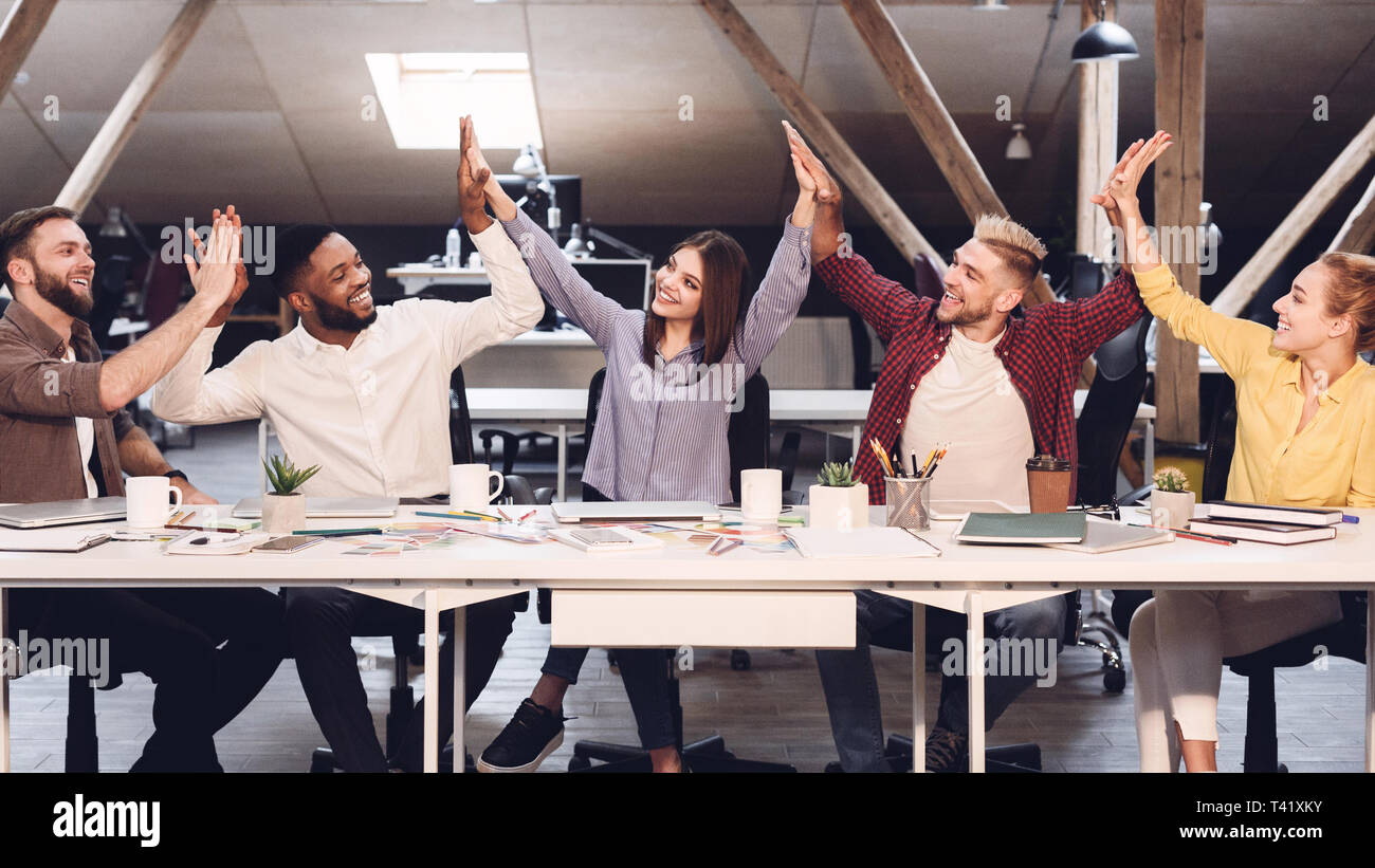 Unità e il lavoro di squadra. I progettisti dando alta cinque per ogni altro Foto Stock