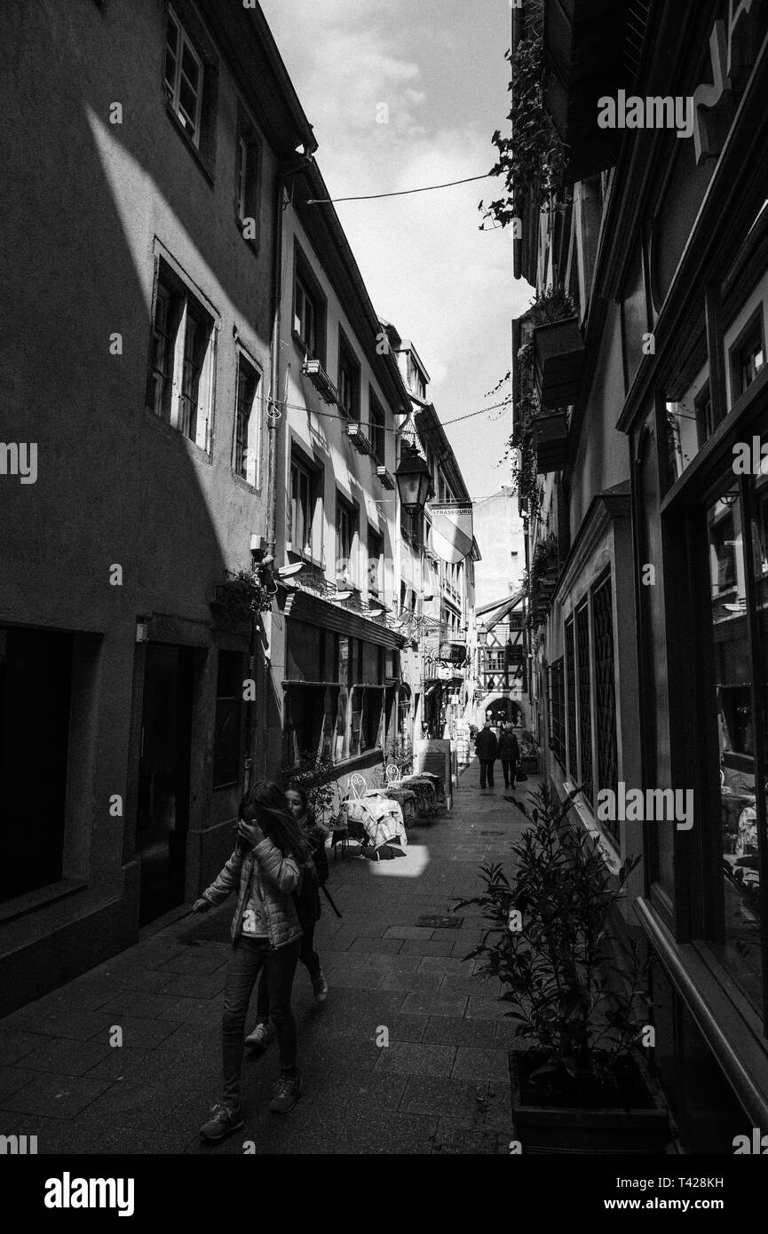 Strasburgo, Francia - 19 Aprile 2016: Cute street tiny vintage case con travi di legno di edifici nel centro di Strasburgo con le Clou winstub tradizionale su 3 Rue du Chaudron - due giovani ragazze divertenti passeggiate Foto Stock