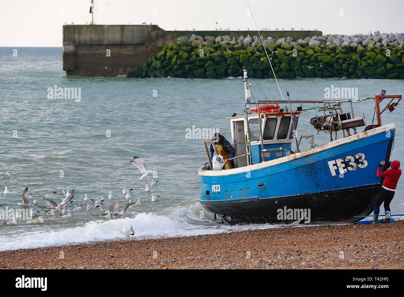 Hastings, East Sussex, Regno Unito. 13 apr, 2019. Regno Unito: Meteo luminosa e fredda mattina di Hastings, East Sussex. I pescatori che a sinistra a ore 5 di questa mattina sono tornati a terra con il pescato del giorno, Hastings ha la più grande spiaggia lanciato della flotta di pesca nel Regno Unito. © Paul Lawrenson 2019, Photo credit: Paolo Lawrenson/Alamy Live News Foto Stock