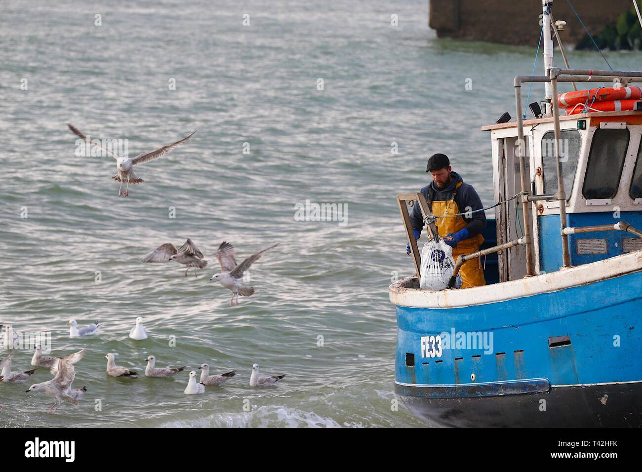 Hastings, East Sussex, Regno Unito. 13 Apr 2019. Regno Unito tempo: Mattina luminosa e fredda in Hastings, Sussex orientale. I pescatori che sono partiti alle 5 di questa mattina sono tornati a riva con il pescato del giorno, Hastings ha la più grande flotta di pesca lanciata sulla spiaggia nel Regno Unito. Pesca barca Hastings. Foto Stock