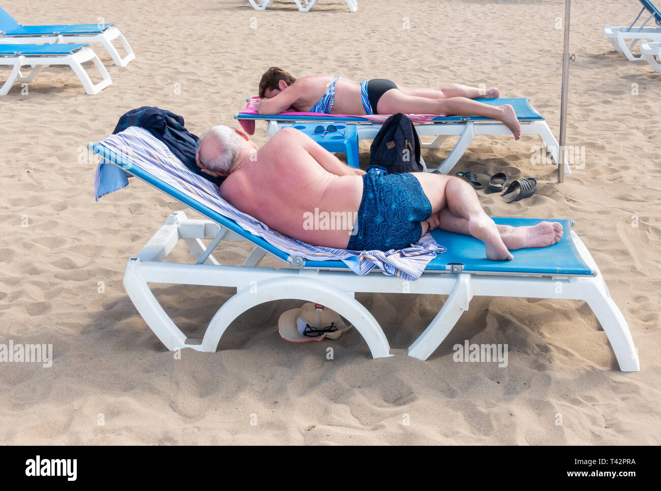 Coppia matura a prendere il sole sulla spiaggia in Spagna Foto Stock