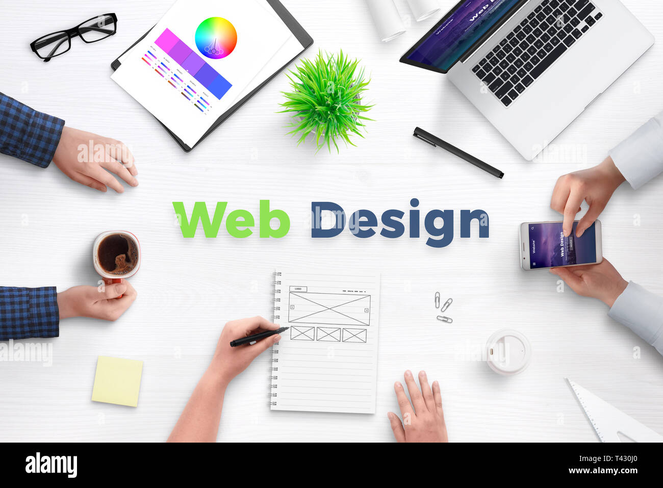 Web design testo sulla scrivania circondato con team di sviluppo web, dispositivi, progetti e idee su carta. Concetto di riunione del team. Foto Stock
