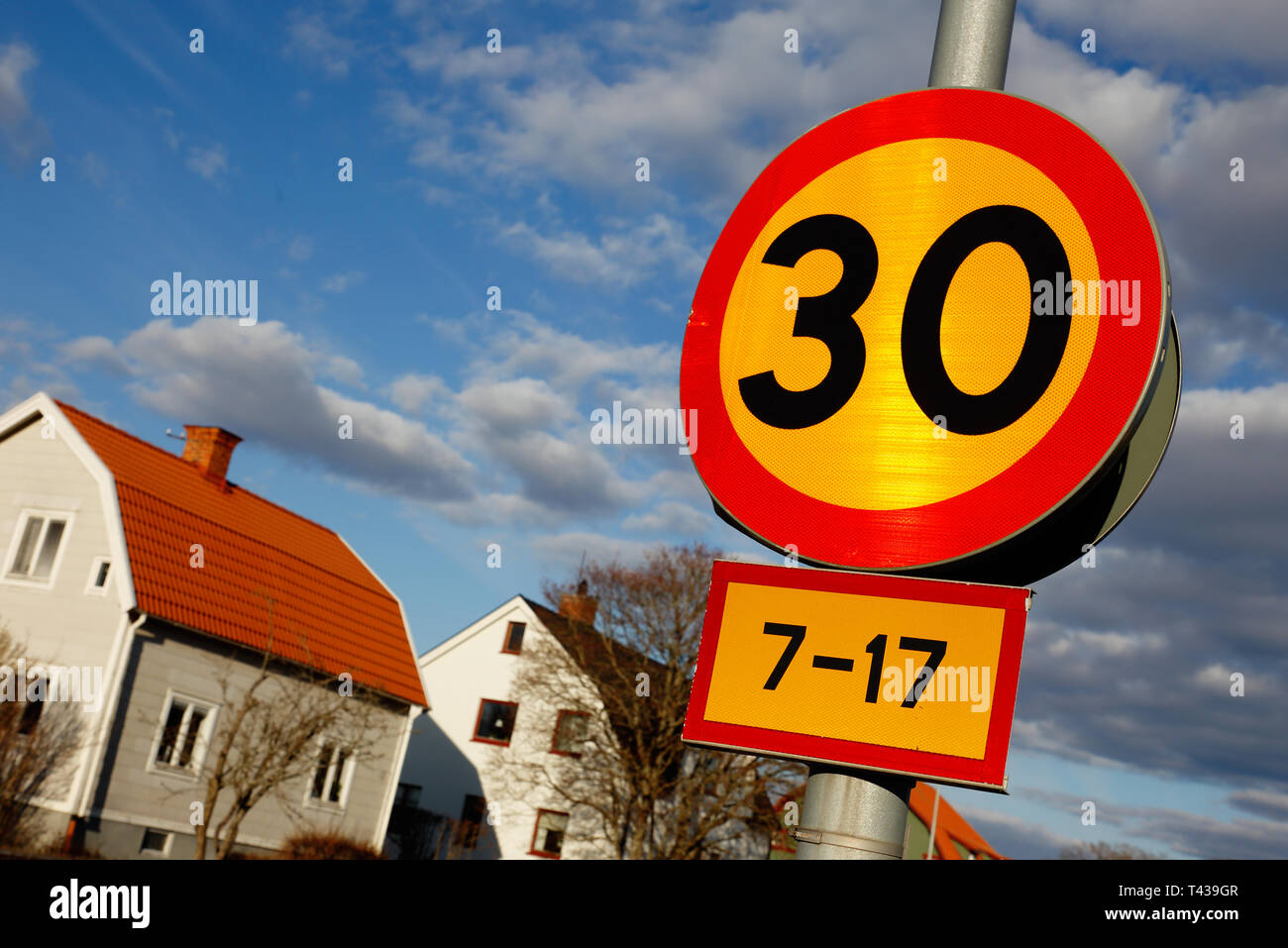 Il limite massimo di velocità 30 cartello stradale situato in area urbana con pannello aggiuntivo indicante il tempo durante i giorni feriali. Foto Stock