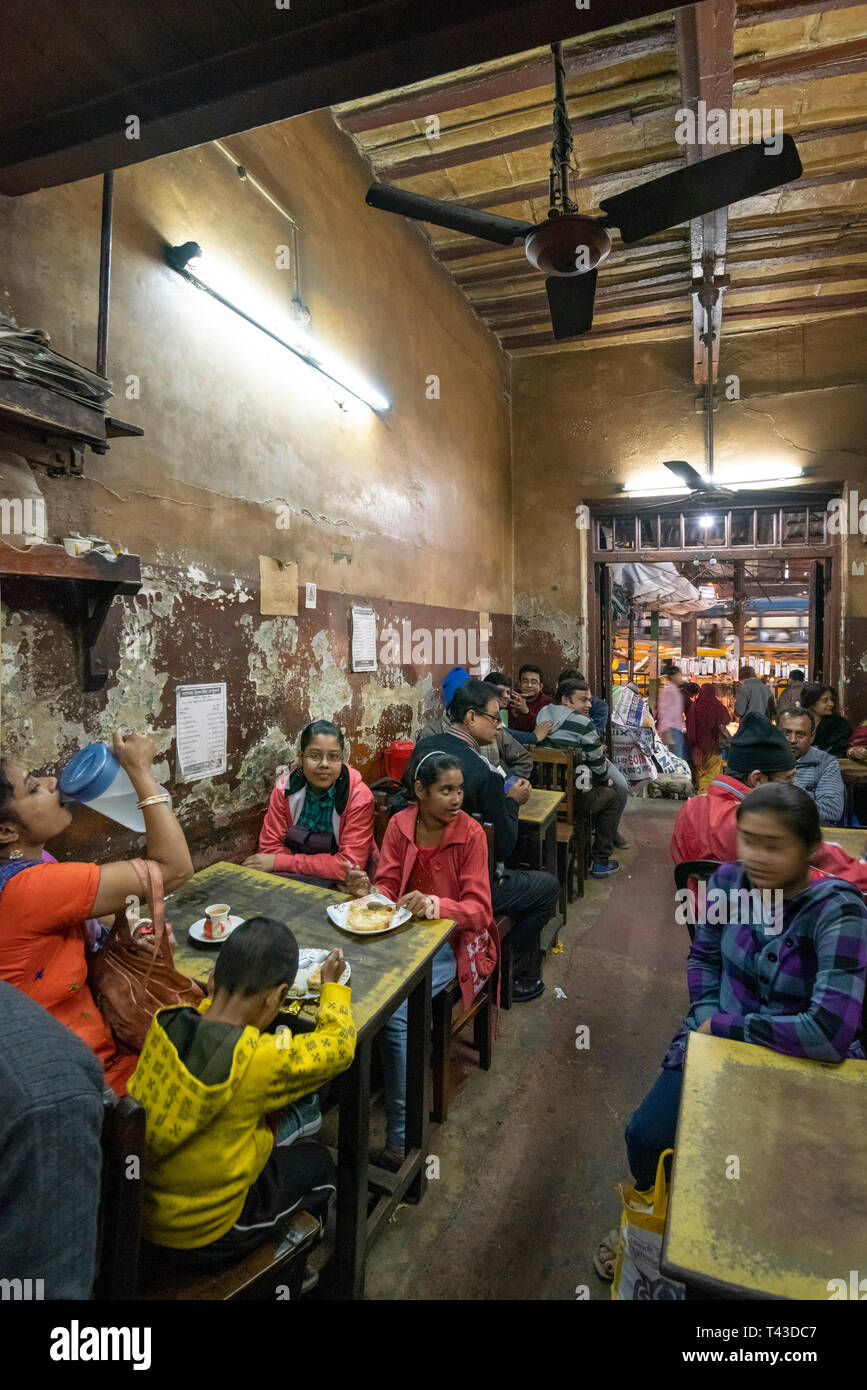 Vista verticale la popolazione locale a mangiare in un ristorante ramshackled in Kolkata aka Calcutta, India. Foto Stock