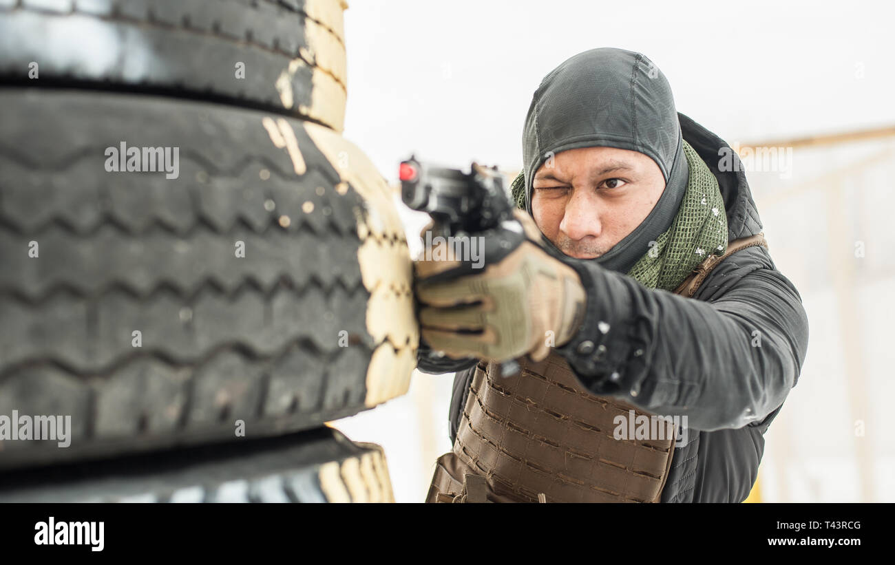 Pistola di combattimento addestramento al tiro da dietro e intorno al coperchio o barricade. Advanced combattimenti tattici corsi di tiro sul poligono di tiro Foto Stock