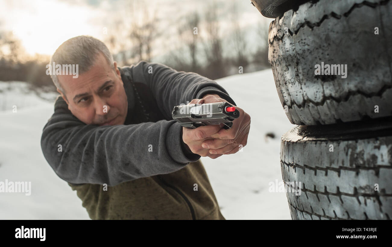 Istruttore di dimostrare la posizione del corpo della pistola di combattimento di scatti da dietro il coperchio o barricade. Advanced combattimenti tattici corsi di tiro su ra di ripresa Foto Stock