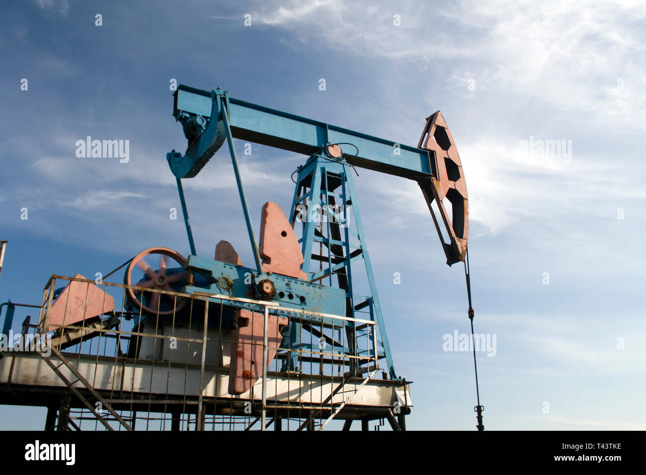 Industria petrolifera e del gas. Il lavoro della pompa olio jack su un campo petrolifero. Cielo blu Foto Stock