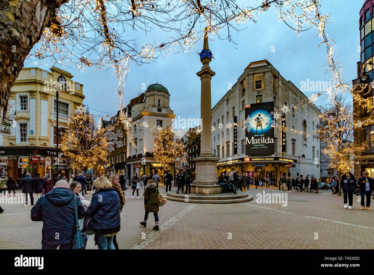 Luci di Natale a Seven Dials, affollate di acquirenti e visitatori che camminano oltre il Cambridge Theatre, mostrando Matilda The Musical , Londra, Regno Unito Foto Stock