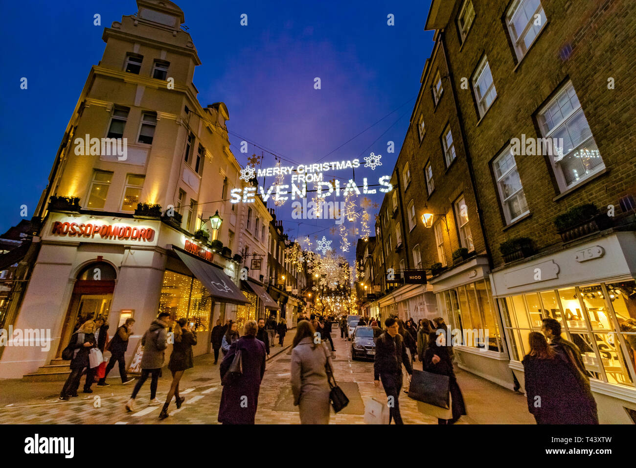 Gli acquirenti e i visitatori che camminano nelle strade trafficate di Seven Dials a Natale, Londra, Regno Unito Foto Stock