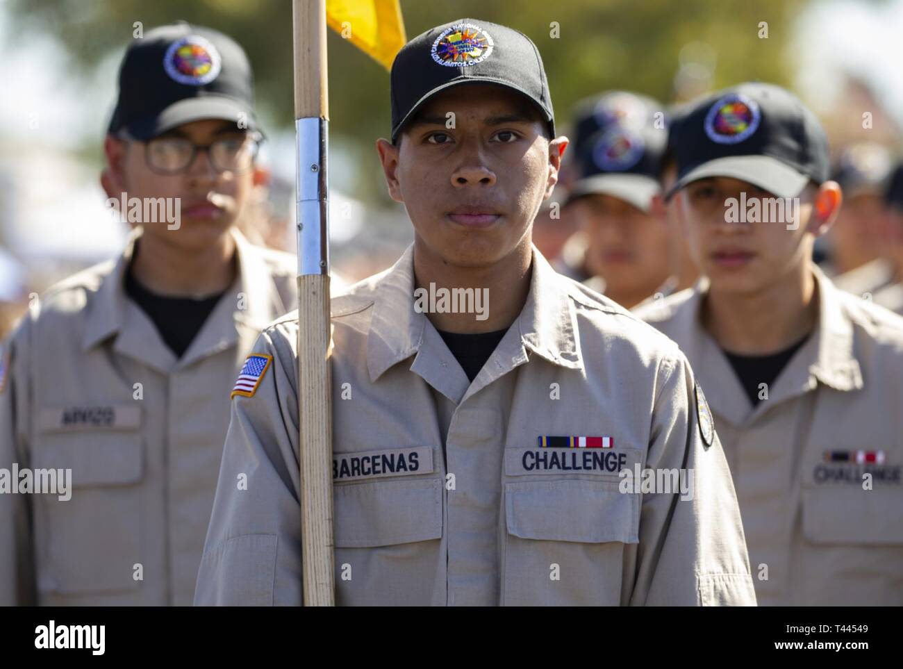 Sunburst sfida della gioventù Academy Cadet Alberto Barcenas porta il Wolfpack guidon come il primo plotone marche sul tampone di perforazione durante l'accademia della classe 23 la Giornata della Famiglia, 16 marzo 2019, a forze congiunte Training Base, Los Alamitos, California. Più di 200 ragazzi, 16-18 anni, nella classe 23 sono circa a metà strada attraverso Sunburst 5.5 del mese programma residenziale che si concentra su accademici, competenze per la vita, leadership, impostazione obiettivo e il successo. Foto Stock