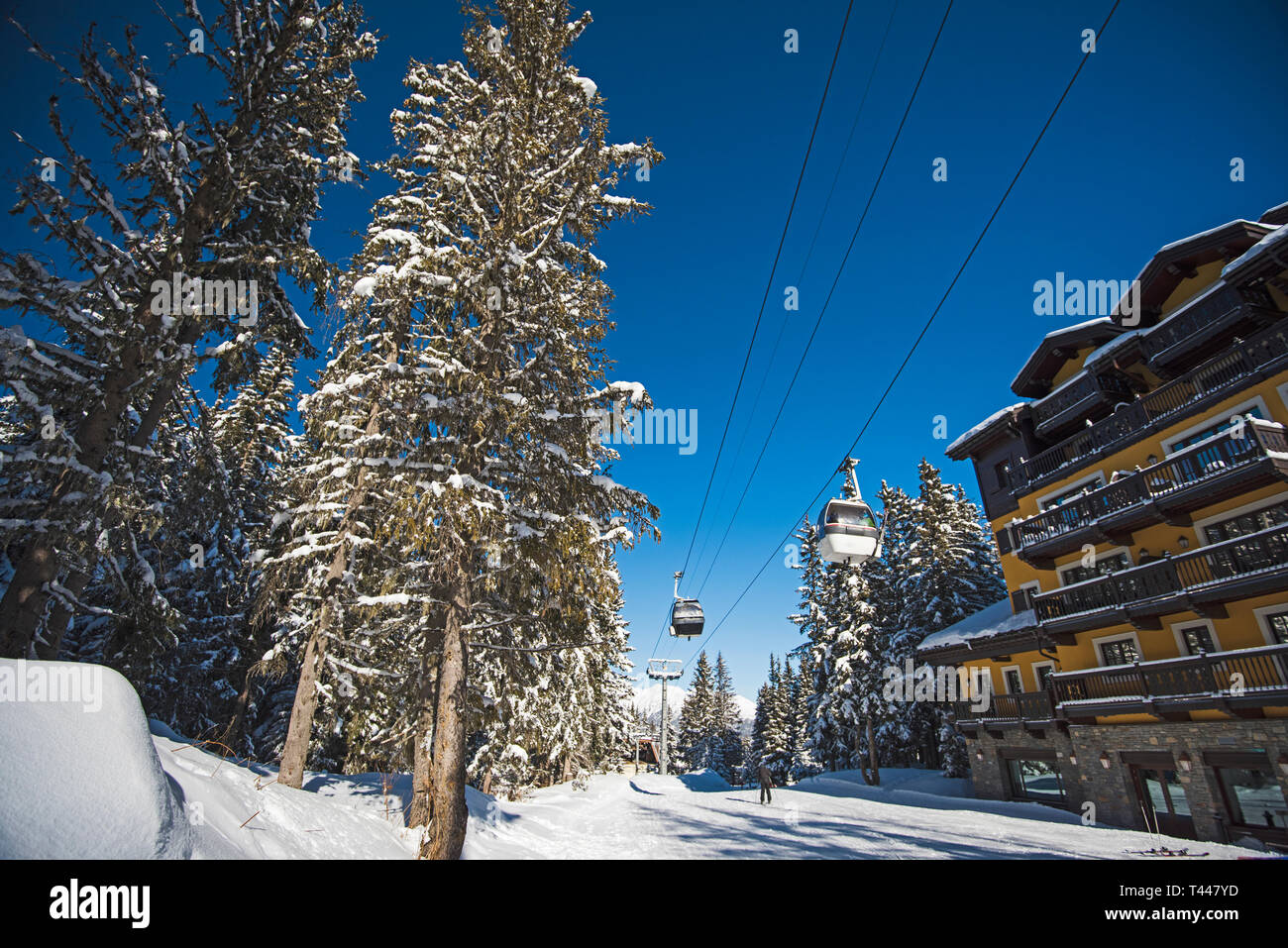 Vista panoramica di una coperta di neve delle piste da sci e gli alberi in una località alpina con funivia sollevare e hotel Foto Stock