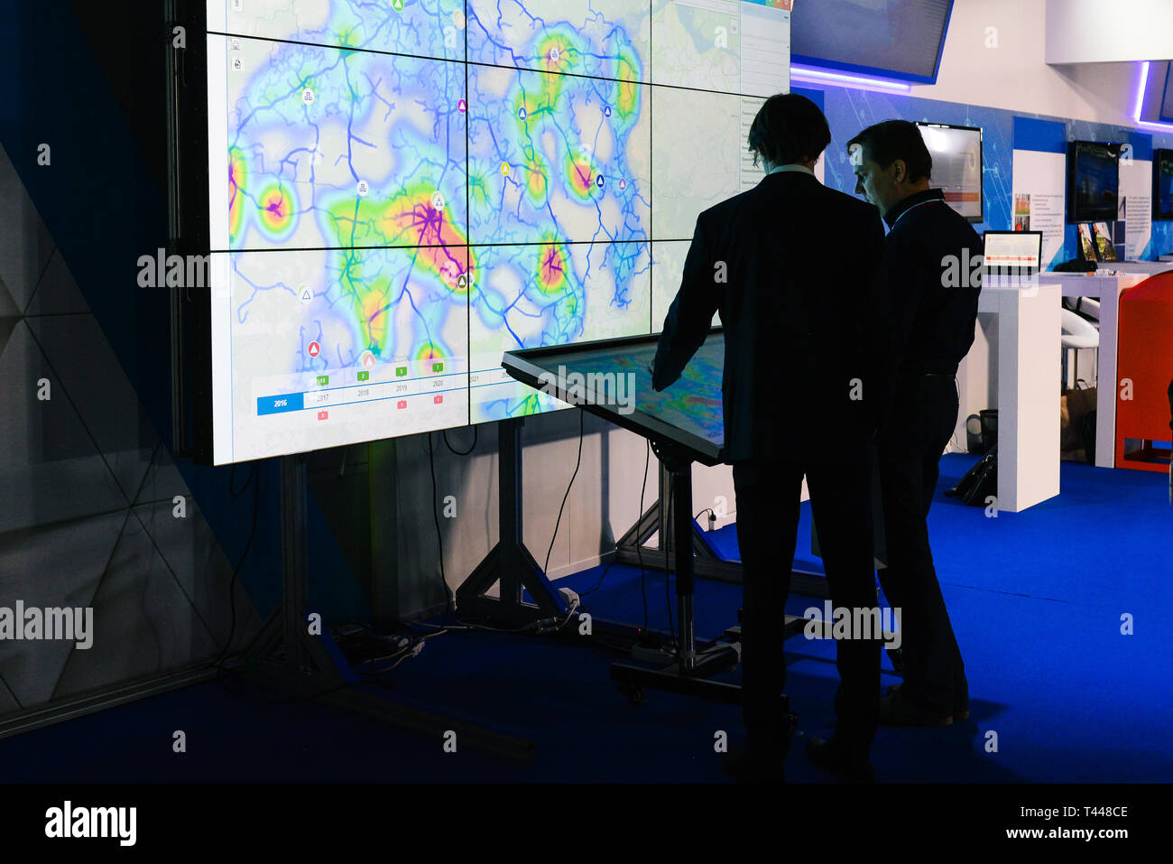 La Russia, città Mosca - Dicembre 18, 2017: i giovani imprenditori sono in piedi accanto a un grande schermo touch screen. Gli uomini di successo stanno discutendo un progetto di business Foto Stock