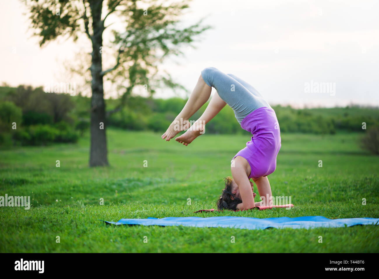 Donna fare yoga all'aperto Foto Stock