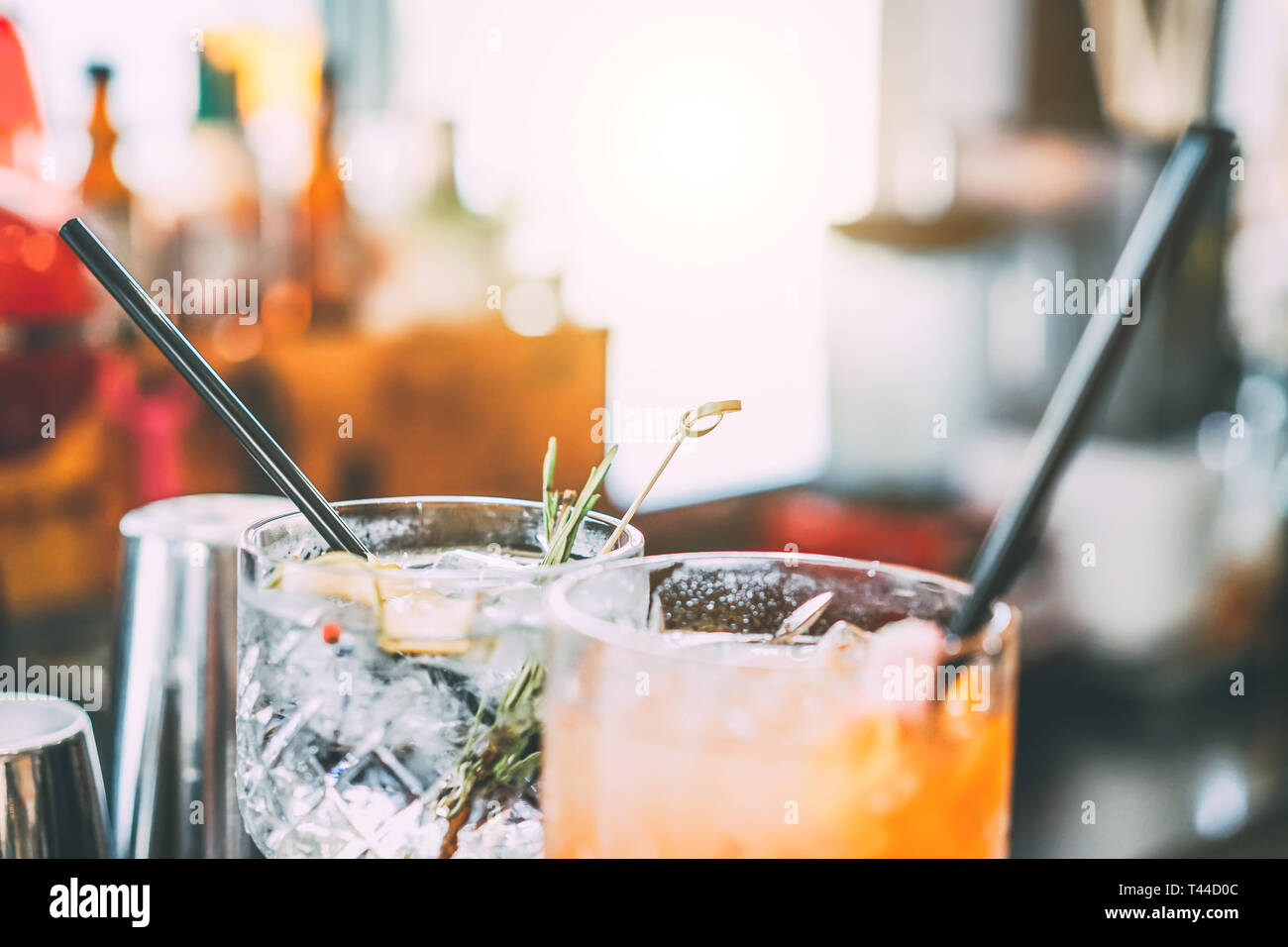 Serve cocktail sul bancone bar preparato con gin, rosmarino, papper e succo di arancia - Bere, vita notturna, il concetto di stile di vita Foto Stock