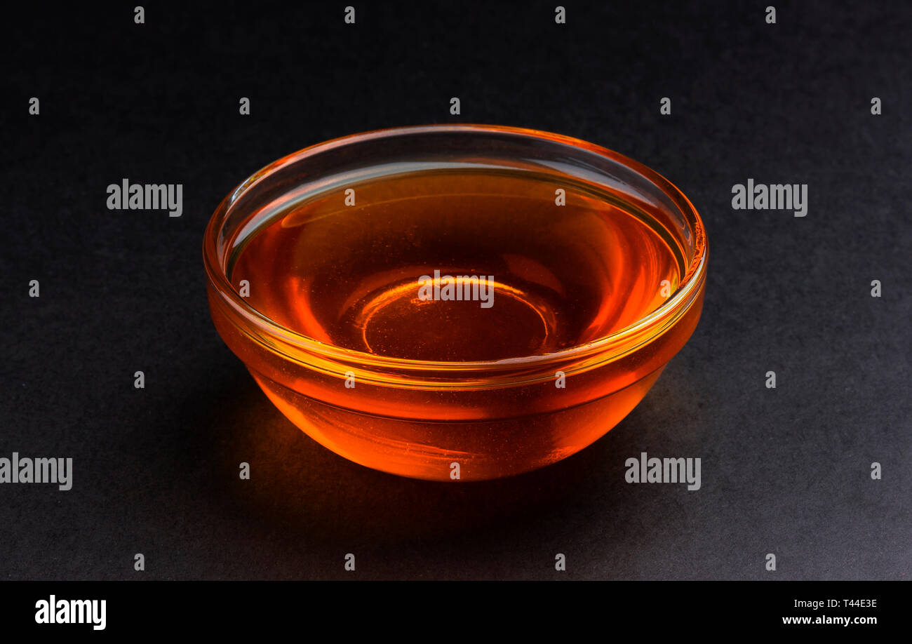 Ciotola di miele su sfondo nero Foto Stock