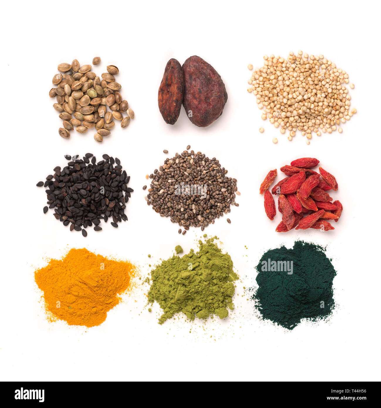 Piccolo mucchio di vari superfoods su sfondo bianco.Super come chia,spirulina,matcha Polvere di tè,materie fava di cacao,goji berry,canapa,la quinoa,sesamo nero,curcuma.Top view.isolato su bianco,tracciato di ritaglio Foto Stock