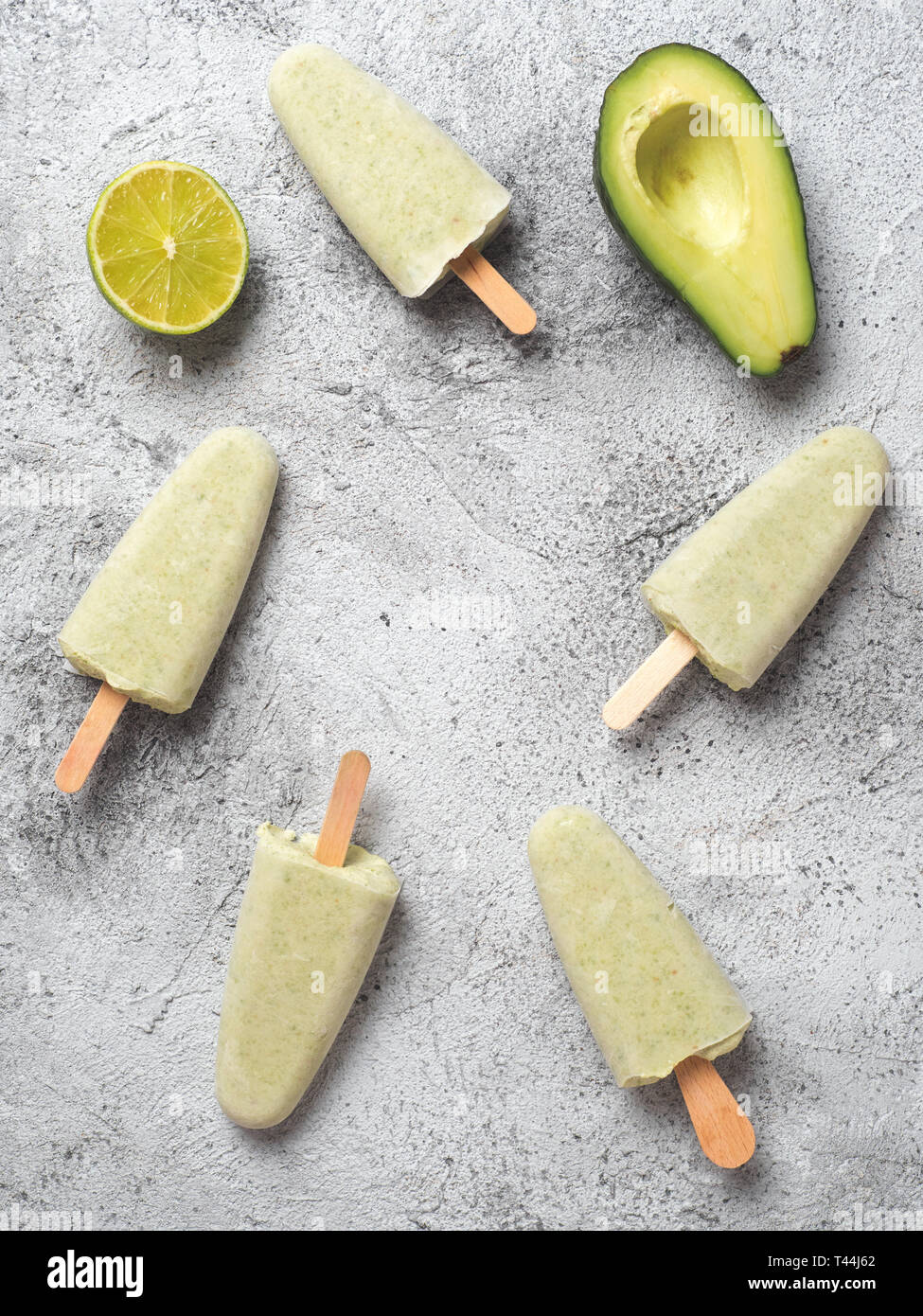 In casa materie vegane avocado lime ghiaccioli. Senza zucchero, non-dairy verde ice cream su sfondo grigio. Copia dello spazio. Vista dall'alto. Idee e ricette per snack sani, dessert o un frullato. Verticale. Foto Stock