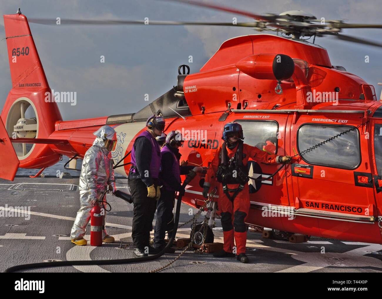 Mar Cinese Orientale (feb. 23, 2019) - USA 7 ammiraglia della flotta USS Blue Ridge (LCC 19) marinai e una guardia costiera crewman aria di fare rifornimento di carburante a U.S. Coast Guard elicottero durante un passeggero comune swap operazione di formazione tra la Guardia Costiera e Blue Ridge. Blue Ridge è la più antica nave operativa in marina e, come 7 comando della flotta navale, lavora attivamente per promuovere le relazioni con gli alleati e partner nella regione Indo-Pacifico. Foto Stock