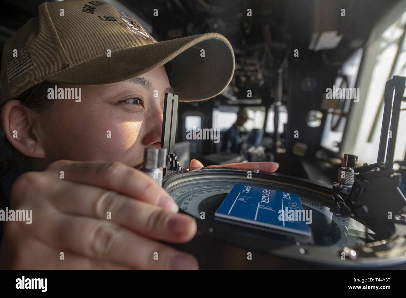 Stati Uniti 5TH FLOTTA AREA DI OPERAZIONI (feb. 24, 2019) - Ensign Steffi Yo utilizza un cuscinetto cerchio mentre conning permanente officer osserva il pilota di casa di Whidbey Island-classe dock anfibio sbarco nave USS Fort McHenry (LSD 43). Fort McHenry è parte dell'anfibio Kearsarge pronto il gruppo e con il ventiduesimo imbarcato Marine Expeditionary Unit, è distribuito negli Stati Uniti Quinta Flotta area di operazioni a sostegno di operazioni navali per garantire stabilità marittimo e la sicurezza nella regione centrale di collegamento del Mediterraneo e del Pacifico attraverso l'Oceano Indiano occidentale e tre strozzatura strategica Foto Stock