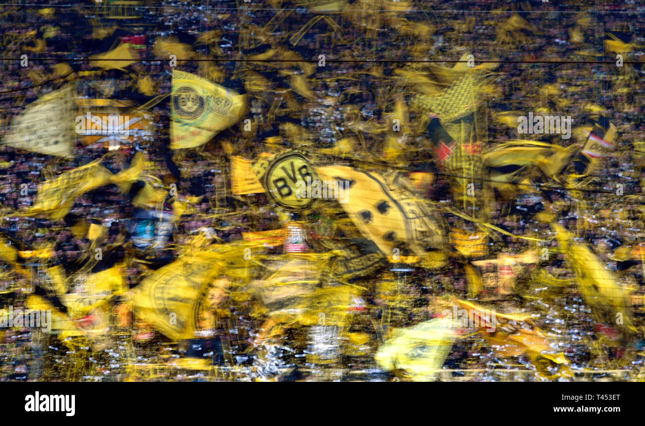 Dortmund, Germania. Xiii Apr, 2019. Calcio: Bundesliga, Borussia Dortmund - FSV Mainz 05, XXIX Giornata al Signal Iduna Park. Gli appassionati di Dortmund wave loro bandiere prima della partita. Credito: Ina Fassbender/dpa - NOTA IMPORTANTE: In conformità con i requisiti del DFL Deutsche Fußball Liga o la DFB Deutscher Fußball-Bund, è vietato utilizzare o hanno utilizzato fotografie scattate allo stadio e/o la partita in forma di sequenza di immagini e/o video-come sequenze di foto./dpa/Alamy Live News Foto Stock