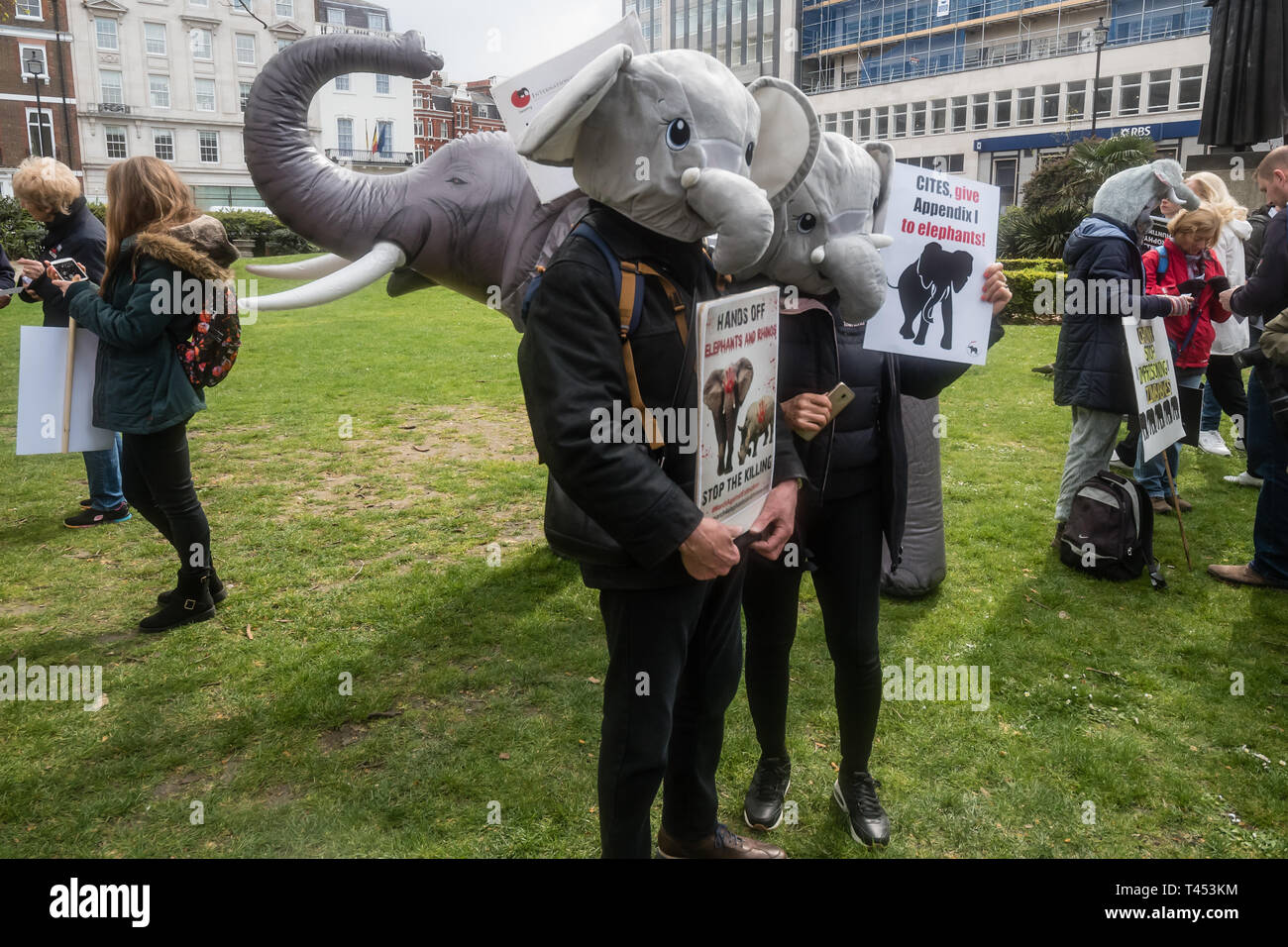 Londra, Regno Unito. Il 13 aprile 2014. Gli attivisti indossando capi di elefante in Cavendish Square prima di marzo a Londra per un rally di fronte a Downing St come una parte del 2019 Global March per elefanti e rinoceronti. Essi hanno invitato il governo britannico a imporre un divieto di importazione di trofei di caccia delle specie in via di estinzione per il Regno Unito e sostenuto un aumento nella protezione sotto la CITES per gli elefanti e si oppone a tentativi di effettuare il downgrade di tutela delle specie in via di estinzione o riaprire il commercio di avorio e di altre parti del corpo. Peter Marshall / Alamy Live News Foto Stock